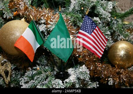 Irish American Natale sfondo: Bandiere irlandesi e americane in miniatura con decorazioni natalizie. Foto Stock