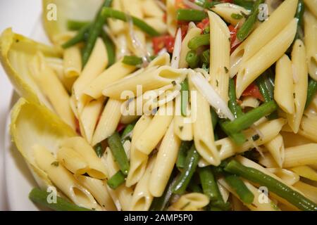 Cucinata fresca penne pasta con fagiolini e pomodori. Foto Stock