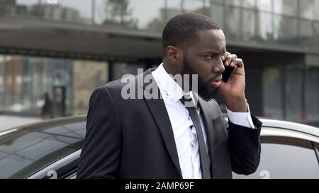 Uomo d'affari confuso che ascolta le minacce da concorrenza di affari, telefonata Foto Stock