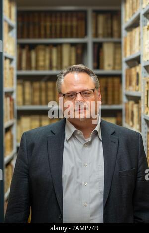 14 gennaio 2020, Sassonia-Anhalt, Lutherstadt Wittenberg: Matthias Meinhardt, capo della 'Wittenberg Research Library for the History of the Reformation', è nella vecchia rivista della biblioteca. Due frammenti unici di pergamena religiosa scritti a mano nella traduzione tedesca sono stati trovati lì, datato 1220 e l'ultimo quarto del 13th secolo. Entrambi i frammenti sono venuti alla luce durante le ispezioni delle scorte e sono stati utilizzati come copertine dei libri. I pezzi possono essere visti dal 21 febbraio al 20 maggio nel Castello di Wittenberg. Foto: Klaus-Dietmar Gabbert/dpa-Zentralbild/ZB Foto Stock