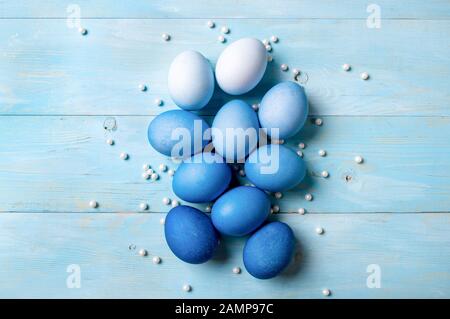Concetto di Pasqua. Uova Ombre in colori blu su sfondo di legno blu con spazio copia per il testo. Vista dall'alto verso il basso o piatto. Colori blu classici a Pasqua 2020 Foto Stock
