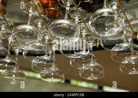 Bicchieri appesi da un rack in un bar o un ristorante. Foto Stock