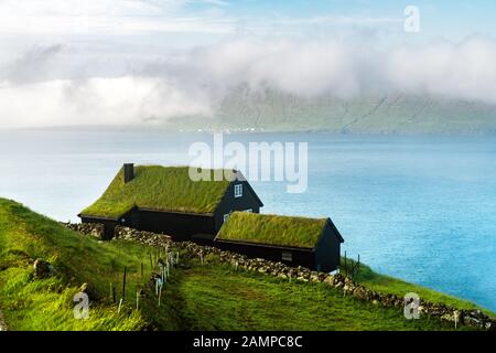 Vista di una casa con tetto in erba nel villaggio di Velbastadur sull'isola di Streymoy, sulle isole Faroe, Danimarca. Fotografia di paesaggio Foto Stock