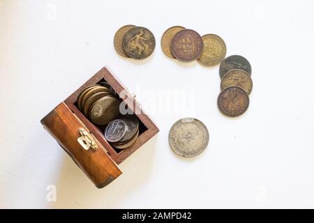 Vari vecchi e ben utilizzati penny sudafricani in un piccolo scrigno di legno su sfondo bianco Foto Stock
