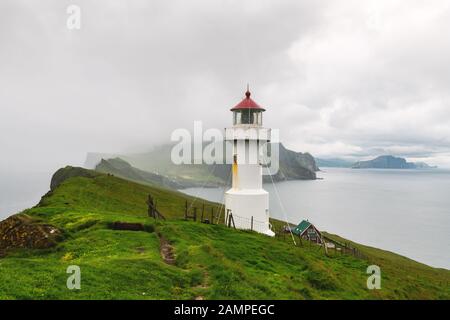La nebbia vista del vecchio faro sulla isola di Mykines, isole Faerøer, Danimarca. Fotografia di paesaggi Foto Stock
