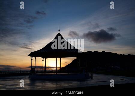 Silhouette di un gazebo sul lungomare di Bray, County Wicklow, Irlanda al tramonto. Foto Stock