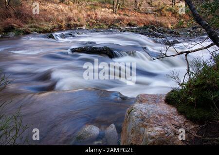 Esposizione lento colpo di White Water Rapids sulle rive di un fiume nella contea di Wicklow, Irlanda. Foto Stock