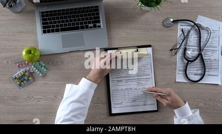 Medico di famiglia che firma prescrizione e forma di assicurazione sanitaria, riforma di sanità Foto Stock