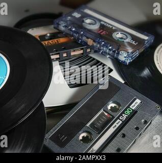 Close up: un nastro pro, cassette audio e 45 RPM vinili. Foto Stock