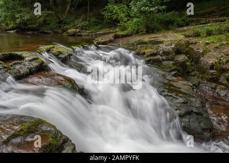 Lunga esposizione della cascata alla piscina del ponte di Watersweet a Watersweet nel Devon Foto Stock