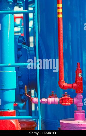 Valvole e tubi colorati in un impianto di produzione di petrolio e gas o prodotti chimici Foto Stock