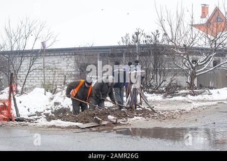 Città del servizio di emergenza di riparazione rottura tubo acqua in inverno. Foto Stock