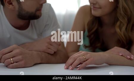 Coppia marito e moglie sdraiata a letto, guardandosi l'un l'altro, famiglia giovane amorevole Foto Stock