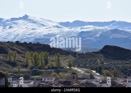 Valli e montagne con vari tipi di alberi in un parco naturale di Granada con la Sierra Nevada in background Foto Stock