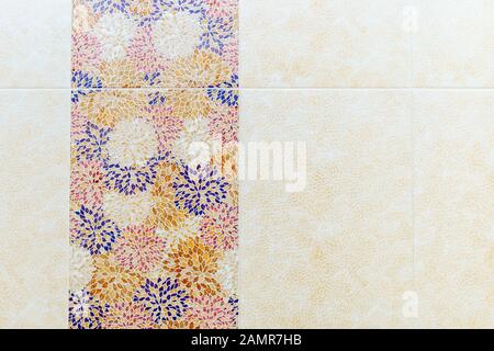 Quadrati di piastrelle in ceramica in forma di blu, giallo, rosso e bianco di modelli di foglia sulla parete in bagno. Bianco-giallo del pattern si alternano con Foto Stock