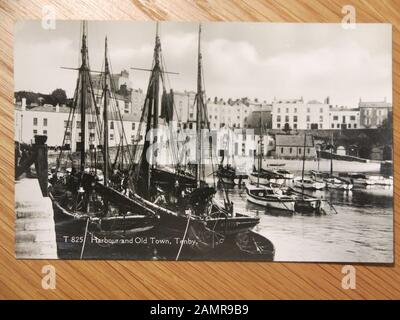 Copia di una vecchia cartolina fotografica in bianco e nero che mostra il porto e la città vecchia di Tenby. Foto Stock