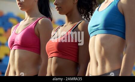 Squadra multirazziale di atleti femminili slim in piedi insieme prima della concorrenza Foto Stock