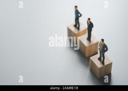 fila di uomini in miniatura su cubetti di legno Foto Stock