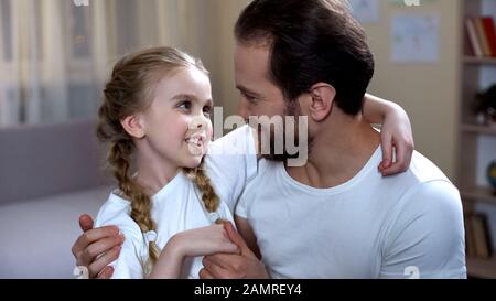 Padre parlando e abbracciando cute bambino, famiglia amore e cura, felice paternità Foto Stock