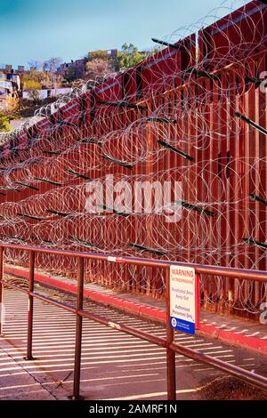 Il muro di confine tra USA e Messico con strati di filo di rasoio a Nogales AZ Foto Stock