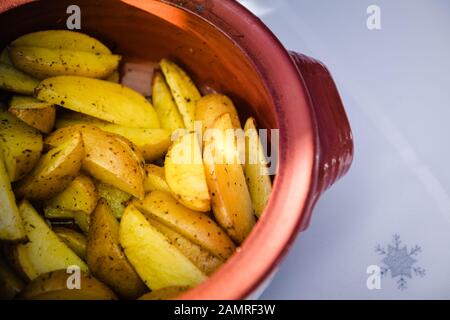 Patate deliziose con erbe aromatiche cotte in forno di argilla rossa Foto Stock