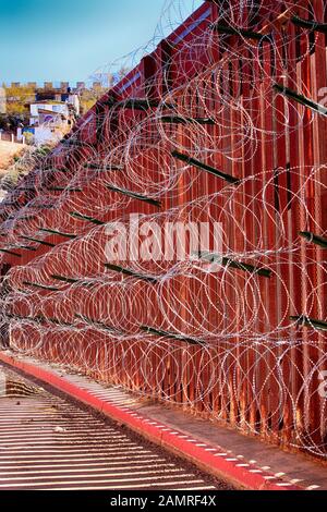 Il muro di confine tra USA e Messico con strati di filo di rasoio a Nogales AZ Foto Stock