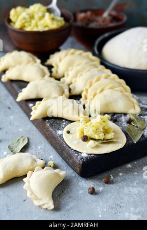 Gnocchi di patate con erbe su uno sfondo blu. Varenyky, vareniki, pierogi, pyrohy - gnocchi con riempimento. Foto Stock