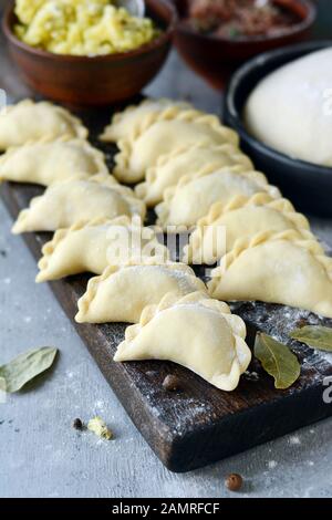 Gnocchi di patate con erbe su uno sfondo blu. Varenyky, vareniki, pierogi, pyrohy - gnocchi con riempimento. Foto Stock
