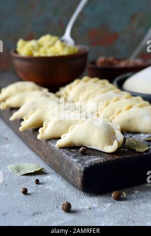 Gnocchi di patate con erbe su uno sfondo blu. Varenyky, vareniki, pierogi, pyrohy - gnocchi con riempimento. Foto Stock