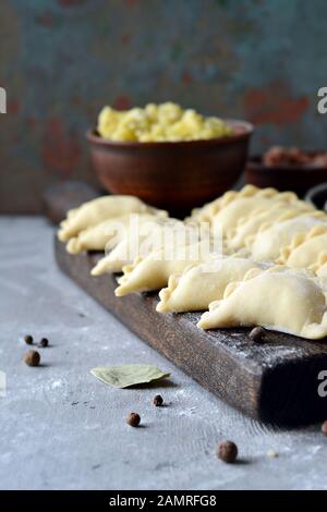 Gnocchi di patate con erbe su uno sfondo blu. Varenyky, vareniki, pierogi, pyrohy - gnocchi con riempimento. Foto Stock