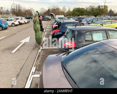 Parigi, Francia - 1° dicembre 2018: L'uomo si prepara ad aprire il bagagliaio dell'auto con l'albero di Natale acquistato presso il negozio di mobili IKEA swedish Foto Stock