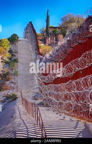 Il muro di confine tra USA e Messico con strati di filo di rasoio a Nogales AZ Foto Stock