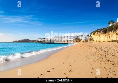 Albufeira villaggio resort, popolare destinazione turistica in Algarve, Portogallo. Onde che si infrangono contro l'ampia spiaggia sabbiosa Praia de Albufeira e vista su Foto Stock