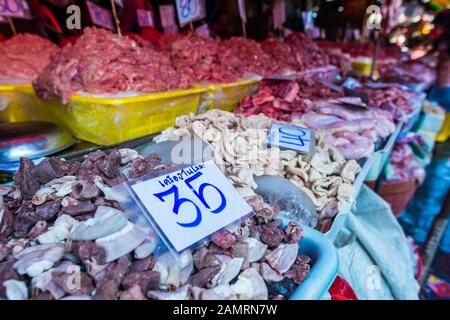 Kholng Toei mercato Bangkok: Markt stallo che vende diversi tagli di carne tra cui stomaco, intestino e altri organi in secchi e prezzo etichettato Foto Stock