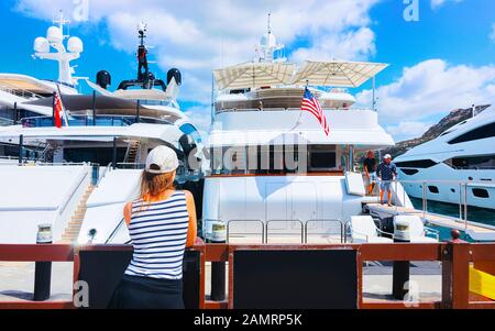 Persone su Embankment con yacht in Porto Cervo riflesso Sardegna Foto Stock