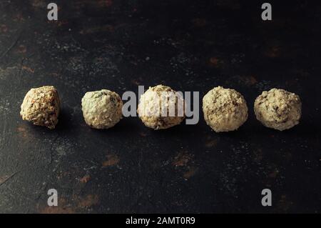 Bulbi di energia cruda con cocco su sfondo scuro. Immagine orizzontale, spazio di copia, vista dall'alto. Foto Stock