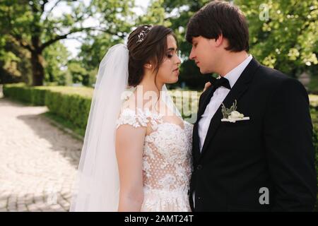 Felice lo sposo e la sposa a piedi nel parco. Donna affascinante con uomo bello trascorrere del tempo insieme Foto Stock
