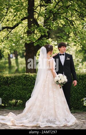 Felice lo sposo e la sposa a piedi nel parco. Donna affascinante con uomo bello trascorrere del tempo insieme Foto Stock