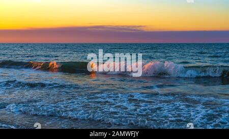 Spiaggia di mare nei colori del tramonto Foto Stock