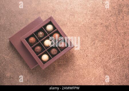 Caramelle fatte a mano in una scatola marrone su uno sfondo scuro. Vista dall'alto. Copia spazio alimentare concetto di vacanza. Telaio orizzontale Foto Stock