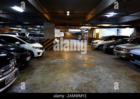 Antipolo City, Filippine - 10 Gennaio 2020: automobili private parcheggiata in un edificio seminterrato parcheggio. Foto Stock