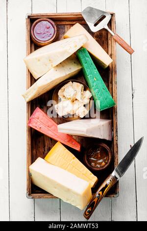 Vari tipi di formaggio servito in scatola di legno. Fette di formaggio Foto Stock