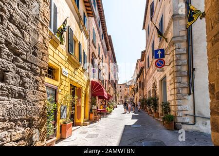 Montepulciano, Italia - 28 agosto 2018: Vicolo stretto in una piccola città della Toscana durante il giorno della soleggiata giornata estiva con persone a piedi Foto Stock