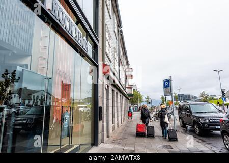 Reykjavik, Islanda - 19 giugno 2018: Due turisti donne che camminano con bagagli nel centro città arrivano in hotel Foto Stock