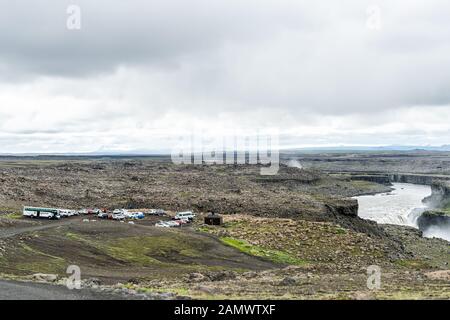 Dettifoss, Islanda - 16 giugno 2018: La cascata islandese si affaccia sul punto con la scogliera rocciosa grigia e le persone che camminano a piedi da parcheggi auto Foto Stock