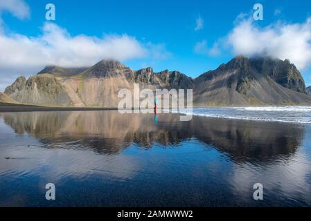Incredibile paesaggio islandese, riflesso del monte Vestrahorn nelle acque dell'oceano Atlantico. Stokksnes Penisola, Hofn, Islanda Foto Stock