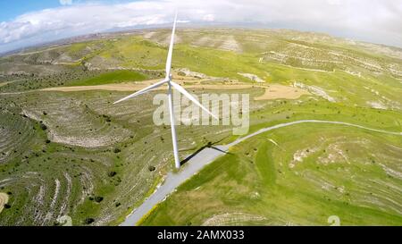 Turbina eolica gigante che fornisce energia verde alternativa, situata in campagna Foto Stock