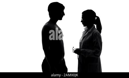 Paziente maschile in visita medica, medico femminile con stetoscopio parla con l'uomo Foto Stock