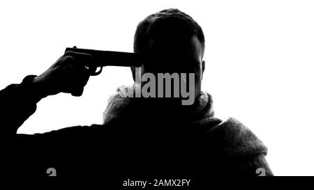 Giovane maschio senza speranza che tiene la pistola che punta alla sua testa, che soffre di emicrania Foto Stock