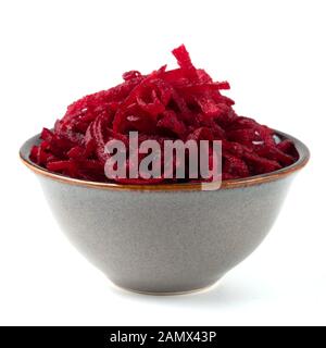 La barbabietola rossa grattugiata nel recipiente di ceramica. Shredded barbabietole da insalata di radice isolato su bianco Foto Stock